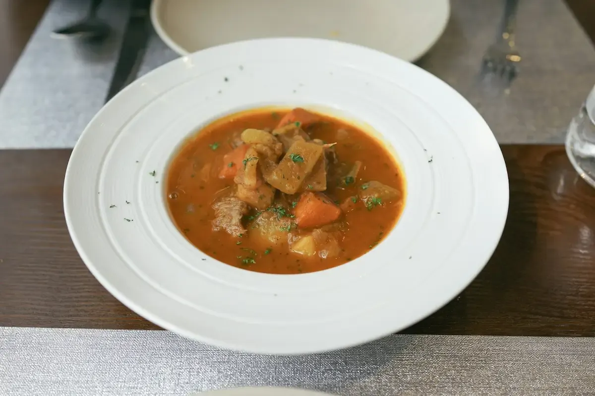 Caldo encorpado com legumes em prato fundo