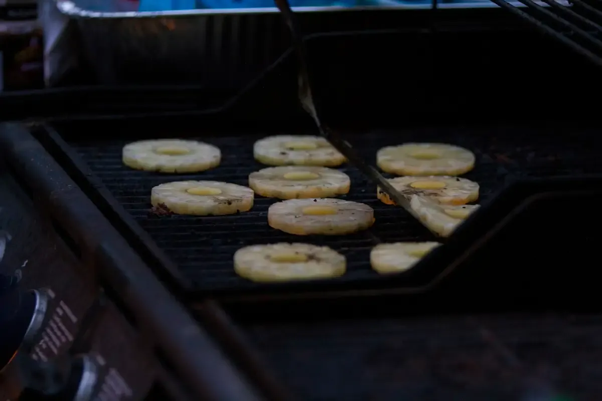 Rodelas de abacaxi dourando na grelha
