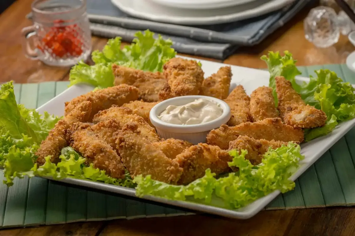 Iscas de peixe douradas com molho