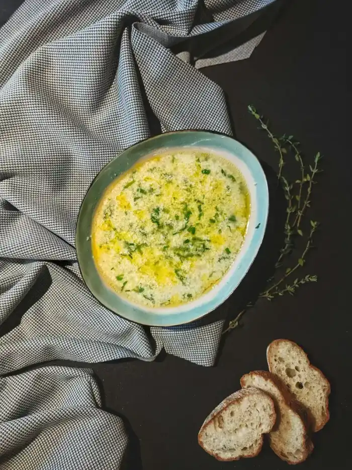 Sopa cremosa com ovo e ervas em tigela