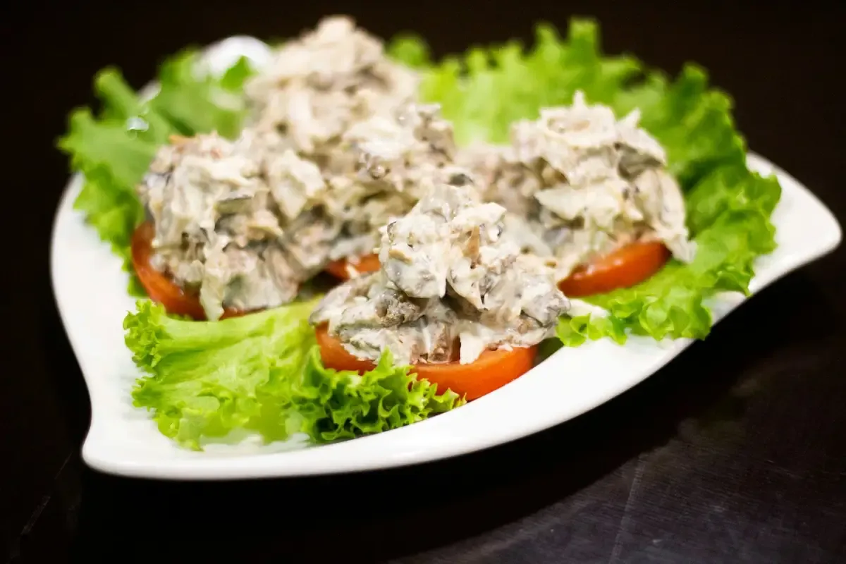 Salpicão cremoso de frango sobre folhas