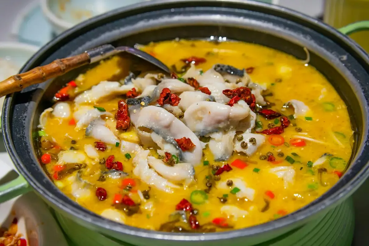 Caldo amarelo com pedaços de peixe